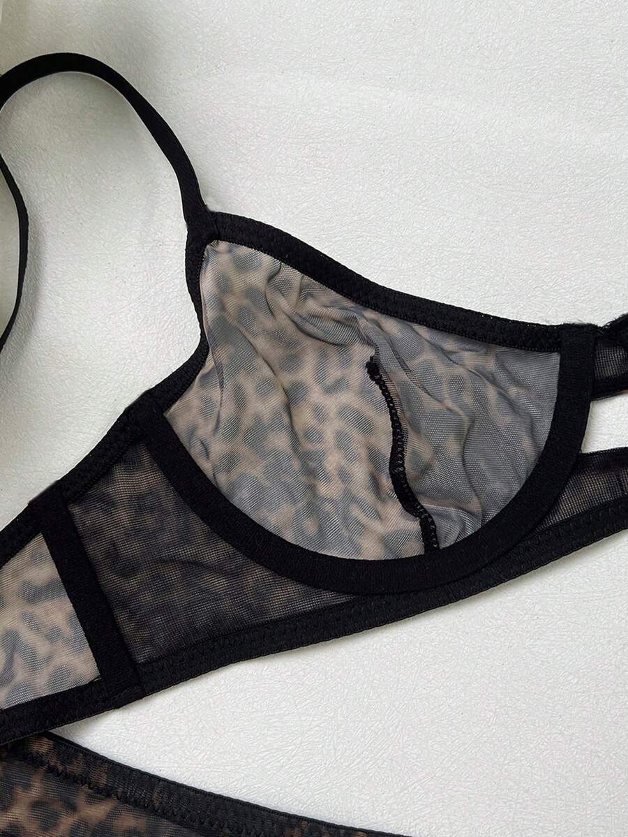 Women's black 2-piece sheer mesh lingerie set featuring an underwire bralette top with cut-out bow details and a matching thong.
