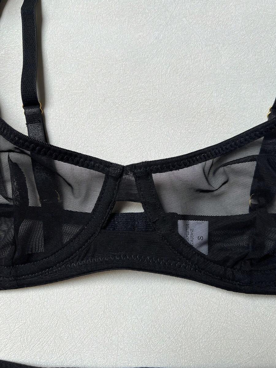 Women's black 2-piece sheer mesh lingerie set featuring an underwire bralette top with cut-out bow details and a matching thong.