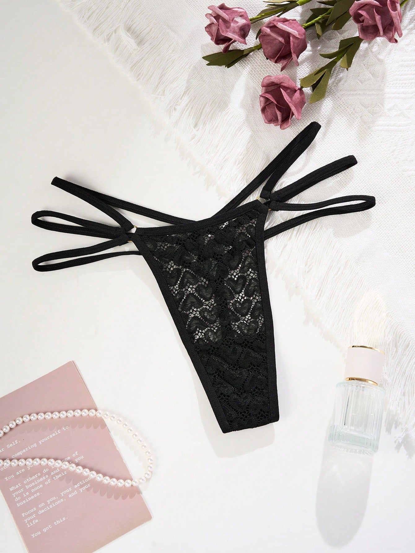 Black women's G-string thong with ring linked cut out design, criss cross straps, striped pattern, and mid-rise fit in stretchy polyamide elastane fabric.