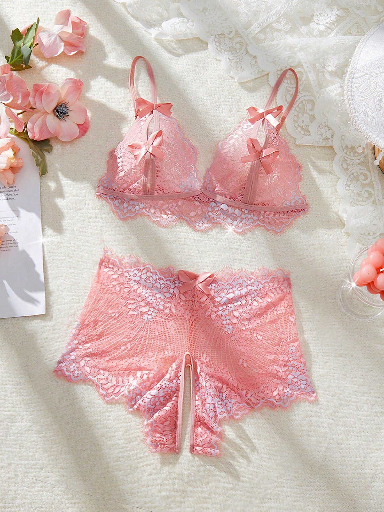 Women's pink lace lingerie set with a wireless bralette, adjustable spaghetti straps, sheer cut-out details, scallop trim, and matching boyshort panties.