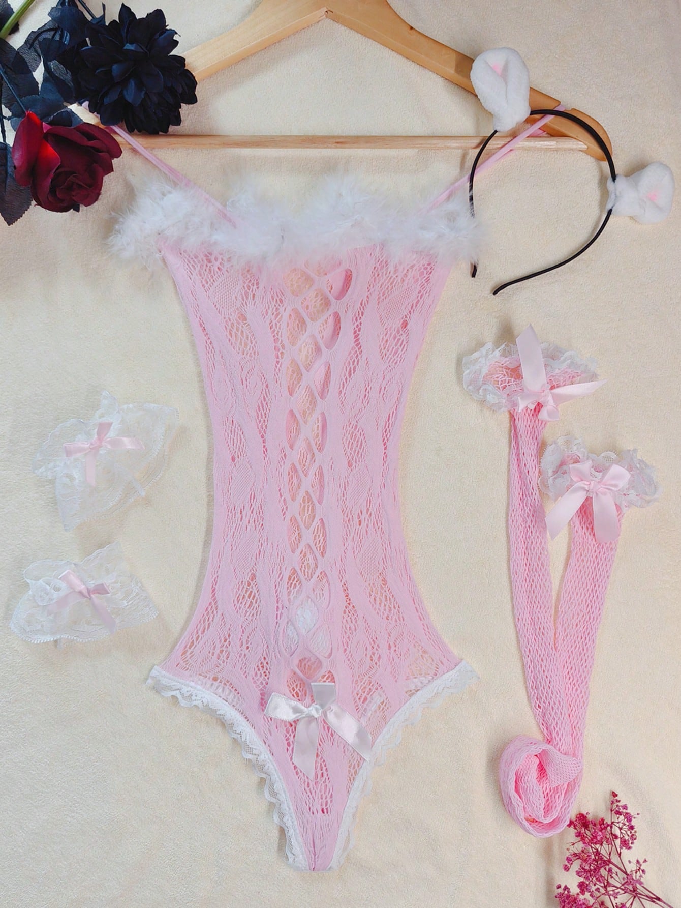 Pink lace bodystocking lingerie set for women with adjustable spaghetti straps, bow detail, contrast faux fur trim, matching headpiece, armband, stockings, and thong.