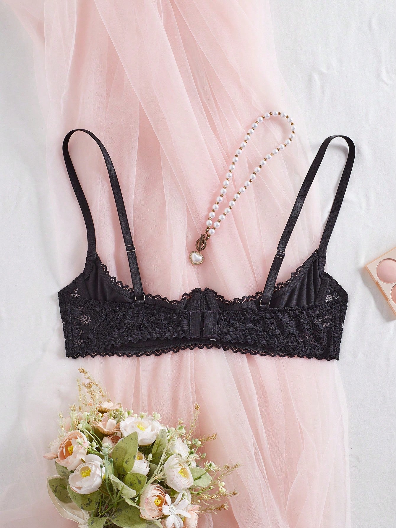 Women's semi-sheer black lace underwire bra with adjustable spaghetti straps, contrast lace detail, 1/2 cup design, and pullover fit.