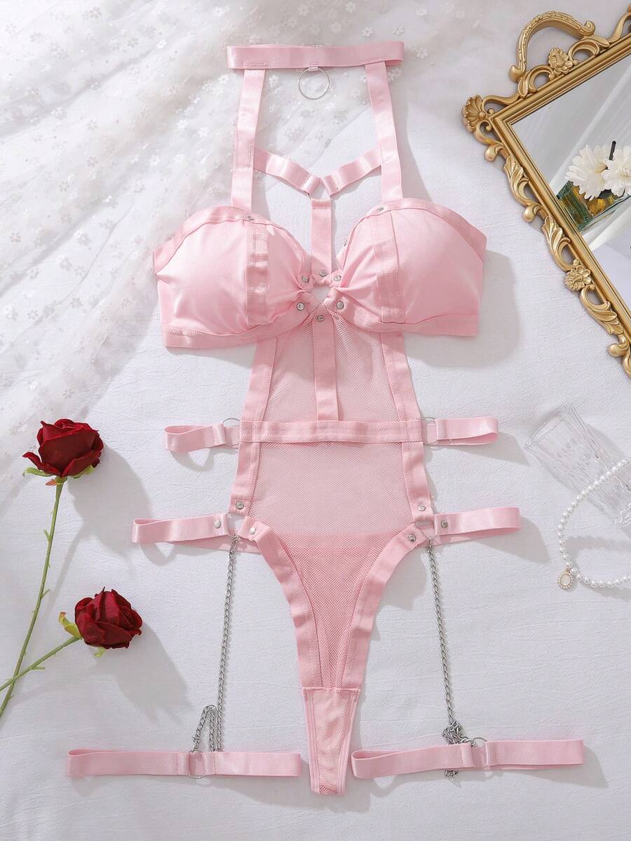 Women's black ring linked harness teddy bodysuit featuring cutout chain details, high rise thong bottom, removable padding, and matching leg rings.
