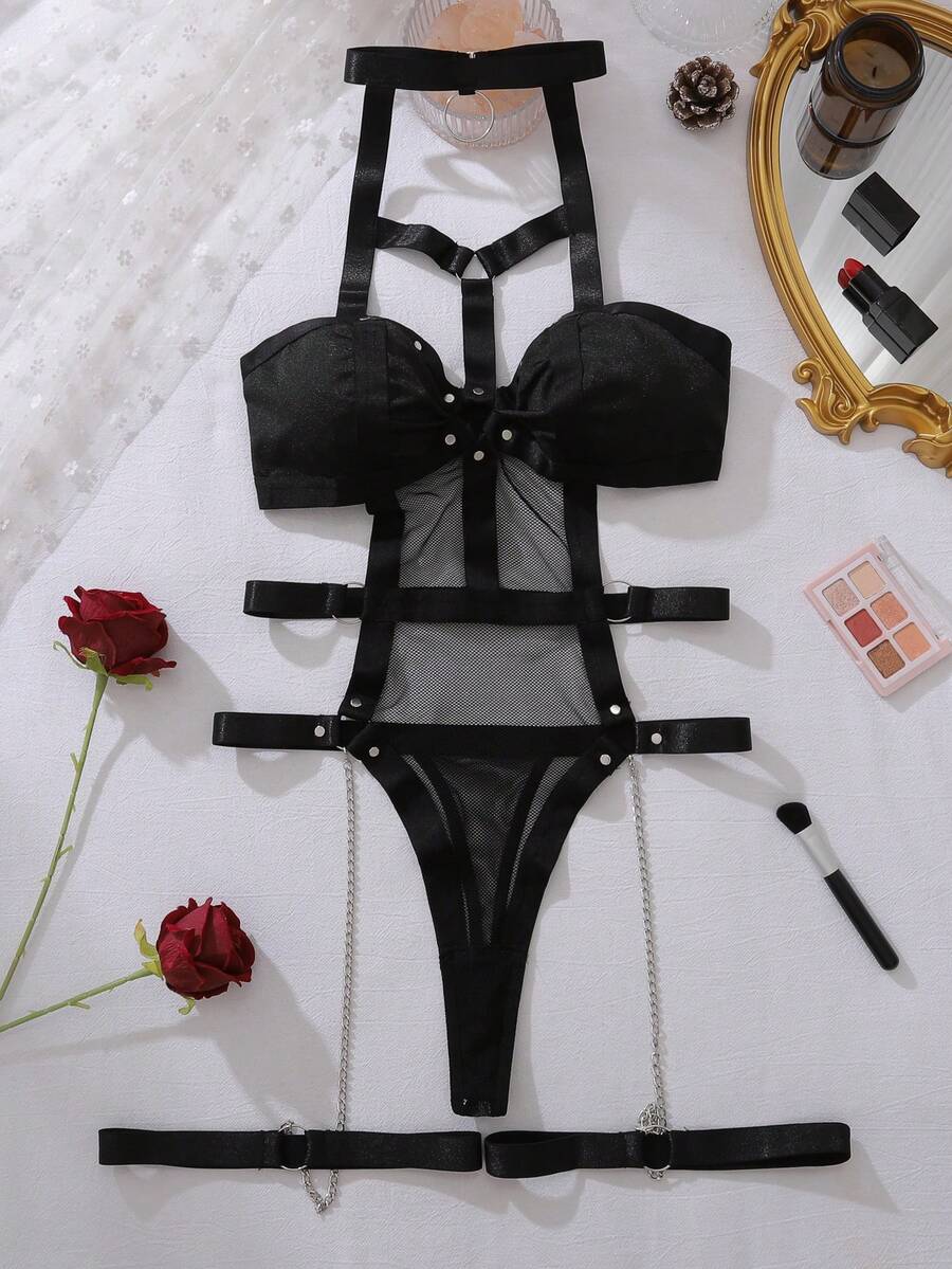 Women's black ring linked harness teddy bodysuit featuring cutout chain details, high rise thong bottom, removable padding, and matching leg rings.