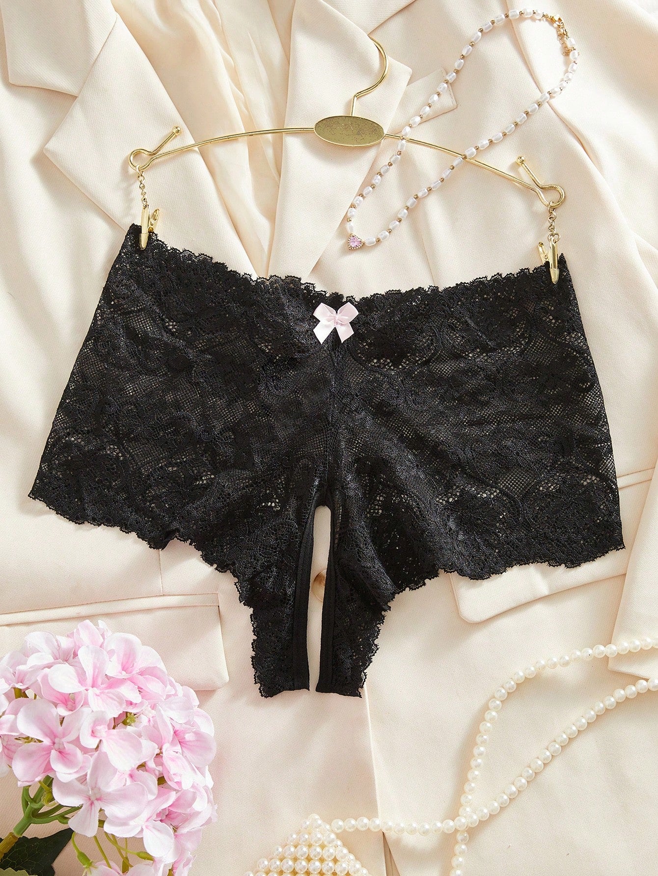 Black women's crotchless lace briefs with a mid-rise fit, textured pattern, cut-out split detail, and slight-stretch romantic styling.