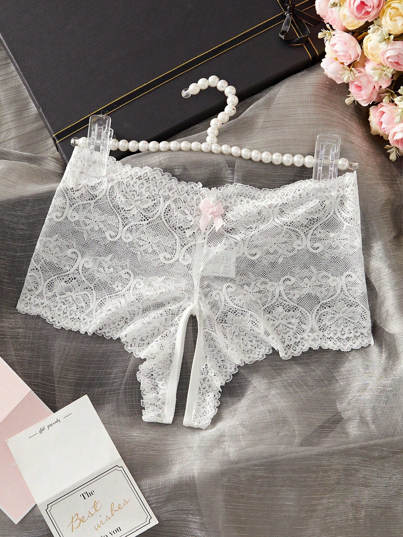 Black women's crotchless lace briefs with a mid-rise fit, textured pattern, cut-out split detail, and slight-stretch romantic styling.