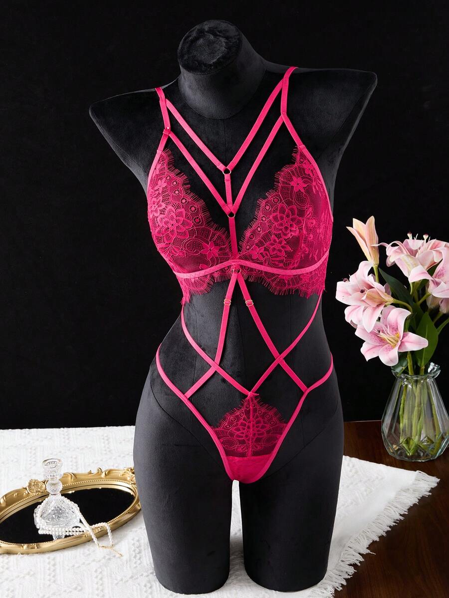 Black floral lace cut-out teddy bodysuit lingerie featuring backless criss-cross design and adjustable spaghetti straps.