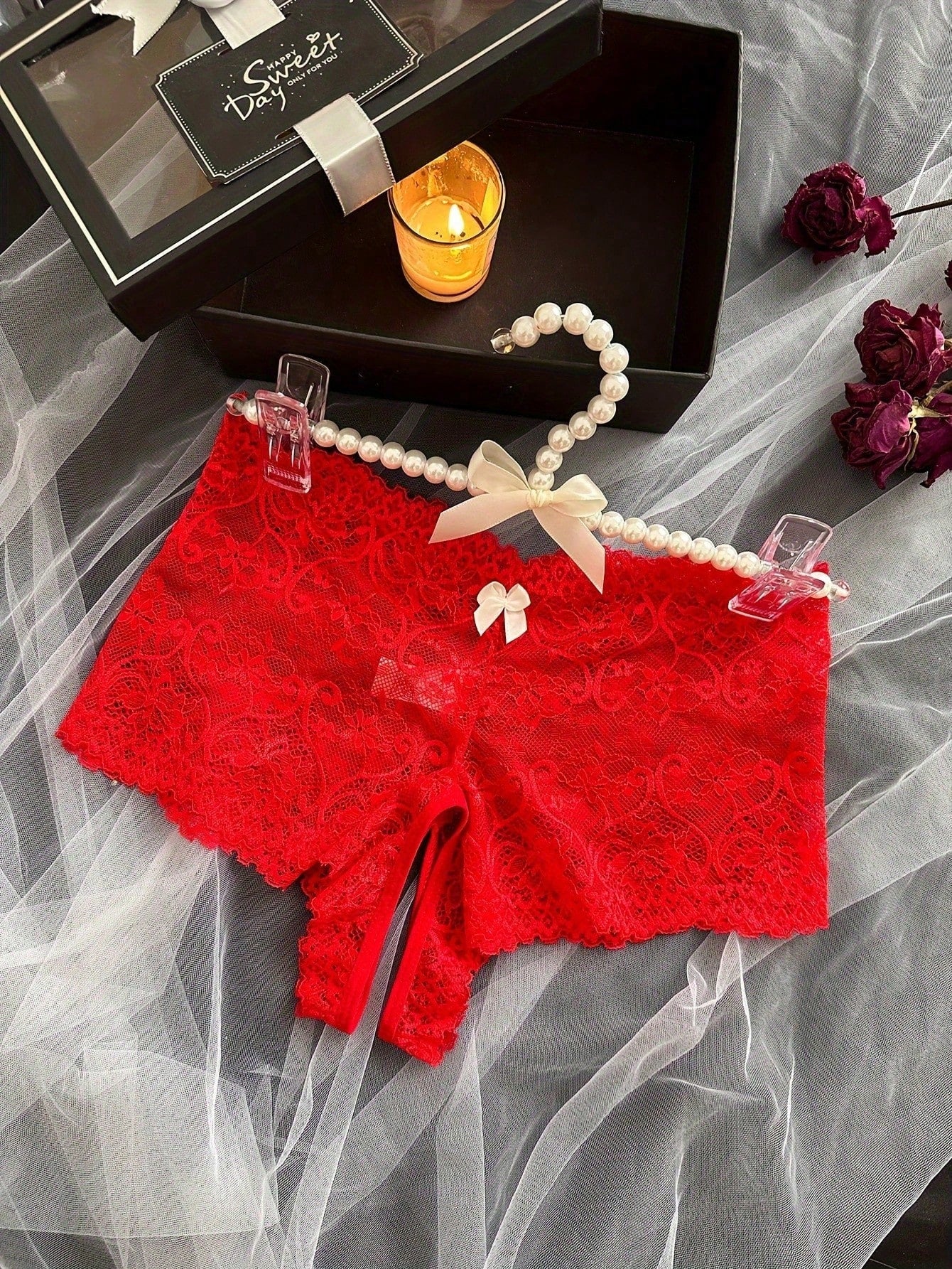 Black women's crotchless lace briefs with a mid-rise fit, textured pattern, cut-out split detail, and slight-stretch romantic styling.