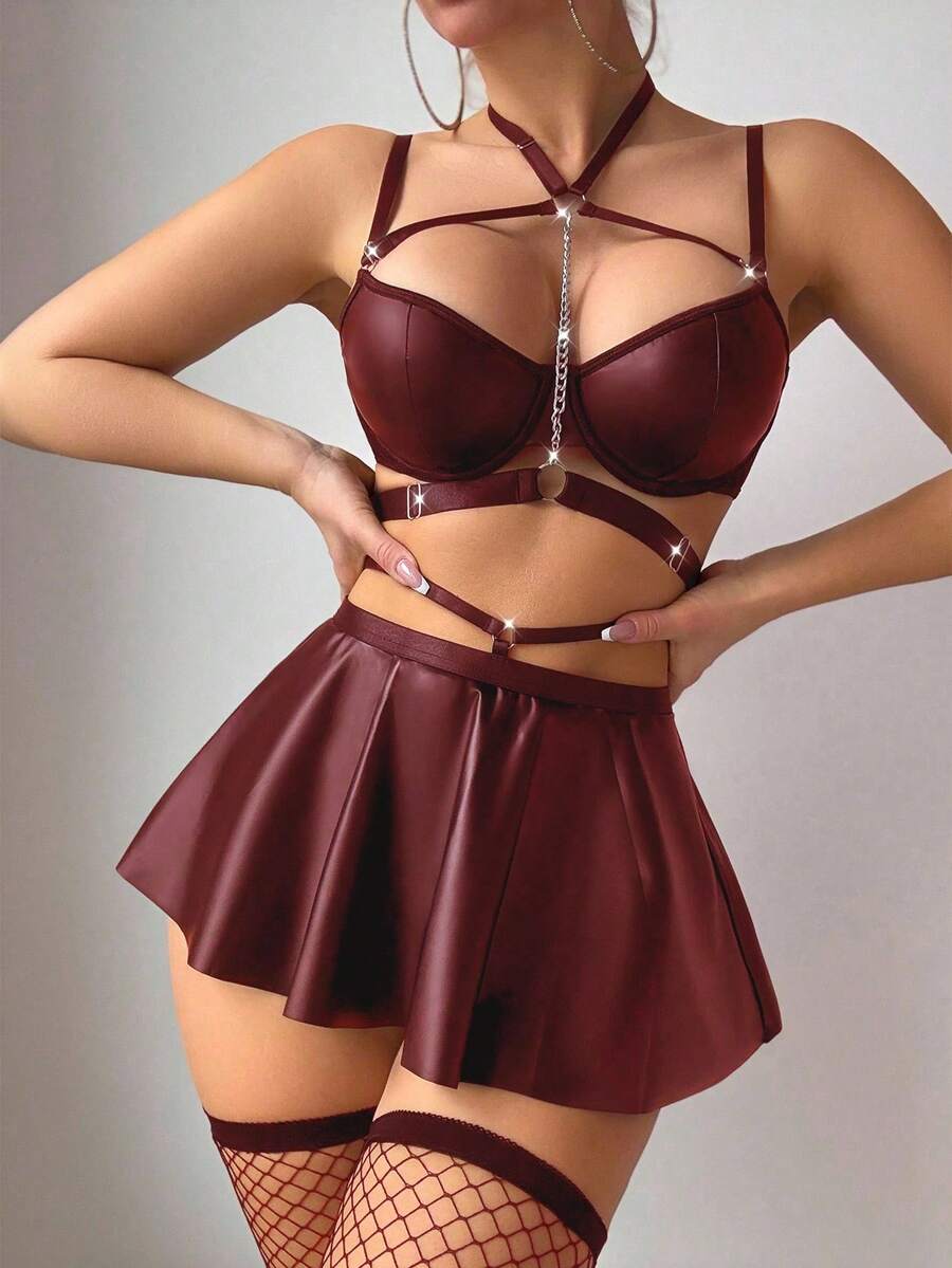 Black 5-piece PU leather lingerie set featuring a chain halter bralette, cut-out mini skirt, and matching thong.