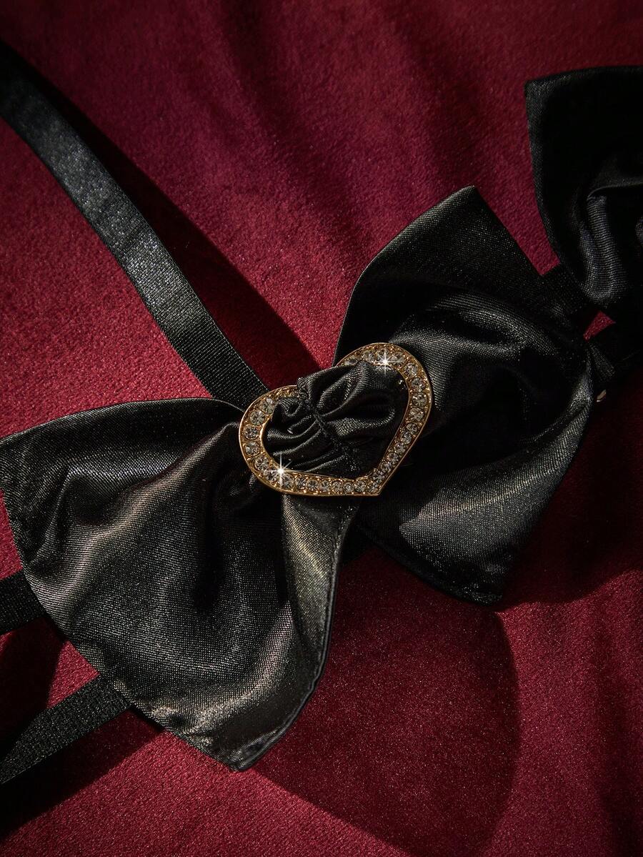 A 2-piece women's black gothic lingerie set featuring a halter bralette top with bow tie and heart detail paired with matching ruffled mid-rise boyshorts.