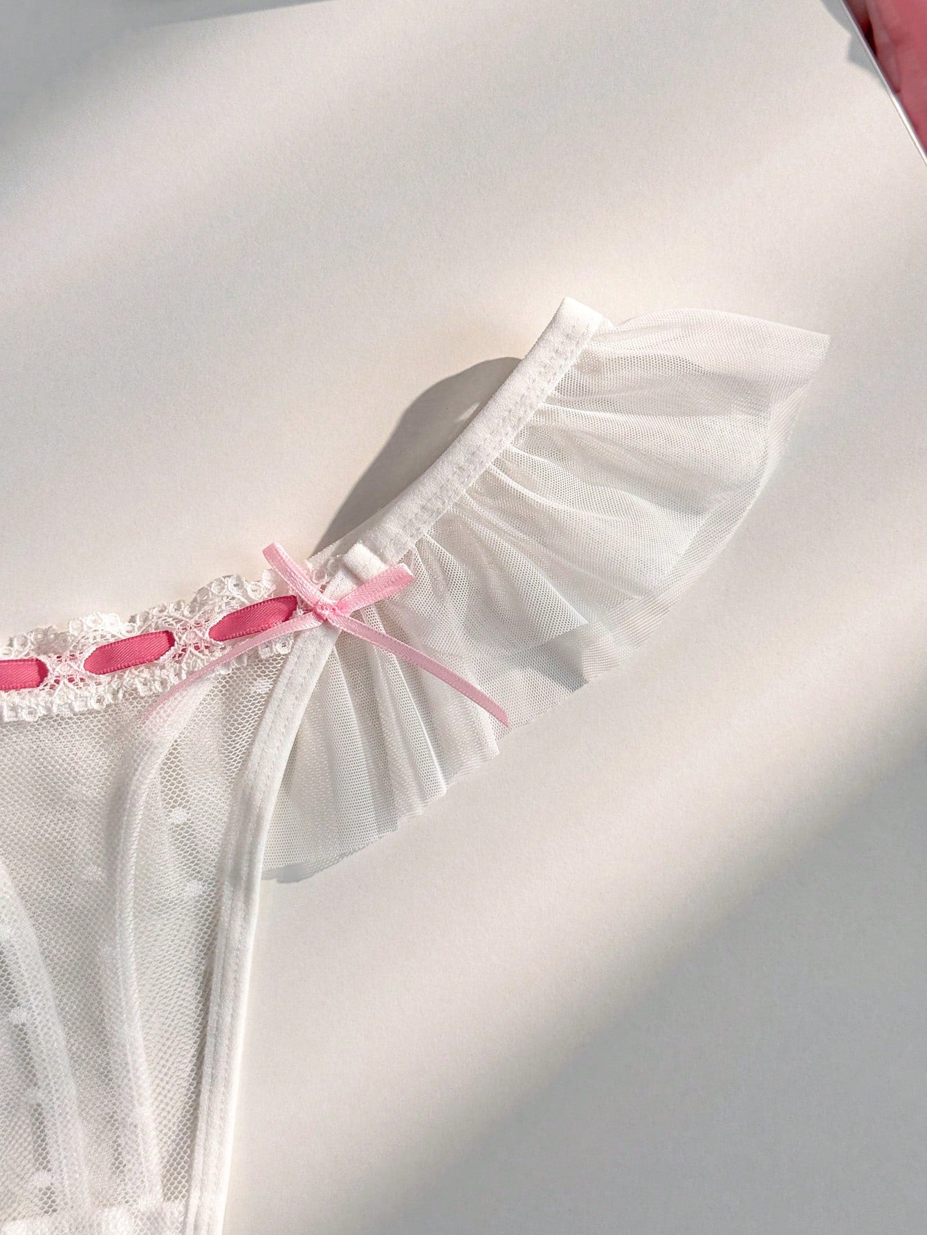 Women's ruffled mesh thong panty with bow detail and mid rise fit, plain design, 1-piece style