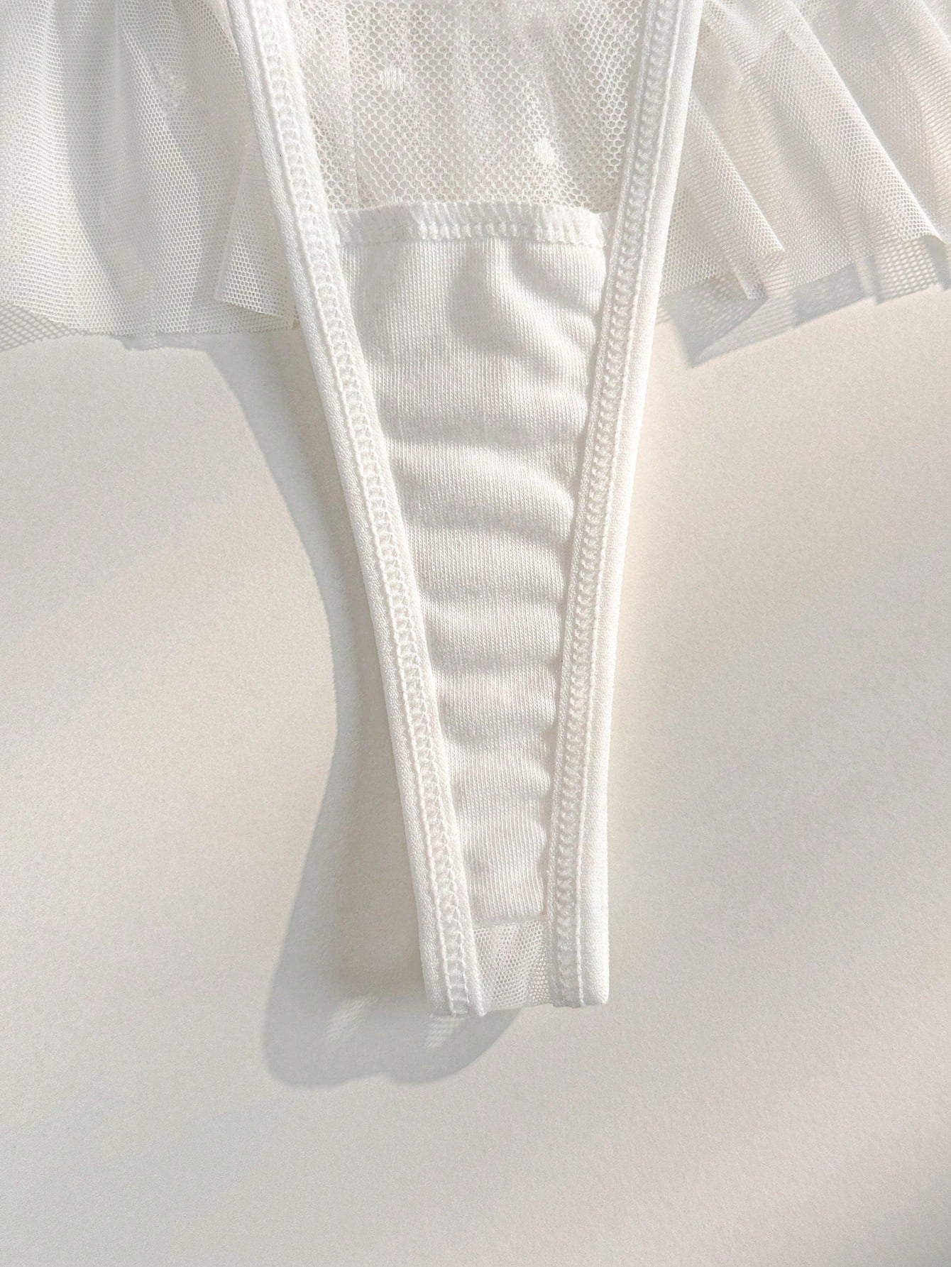 Women's ruffled mesh thong panty with bow detail and mid rise fit, plain design, 1-piece style