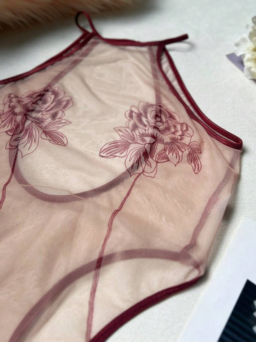 Women's sheer floral mesh teddy camisole featuring cut-out backless design, round neck, adjustable straps, and thong panty in burgundy.
