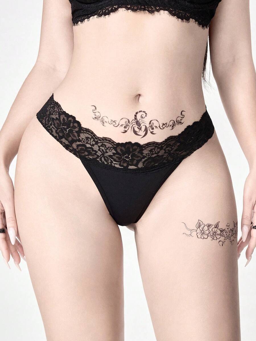 Gothic lace thong panties in black featuring low rise waistband with cross strap and bow detail