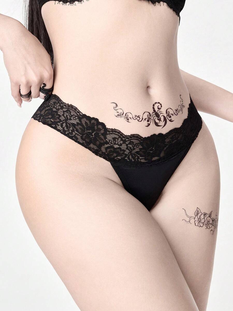 Gothic lace thong panties in black featuring low rise waistband with cross strap and bow detail