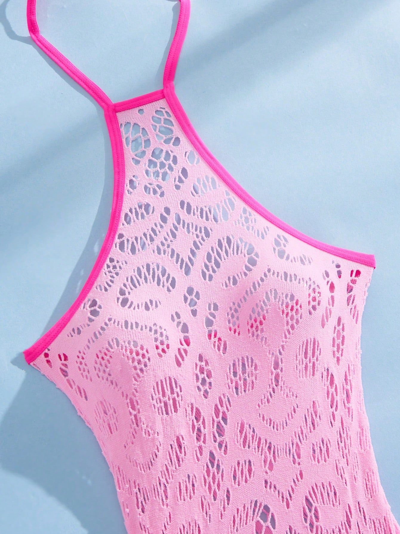 Women's semi-sheer mesh lingerie bodysuit set with halter neckline, backless design, hollow out details, bow accent, and thong styling in pink colorblock fabric.