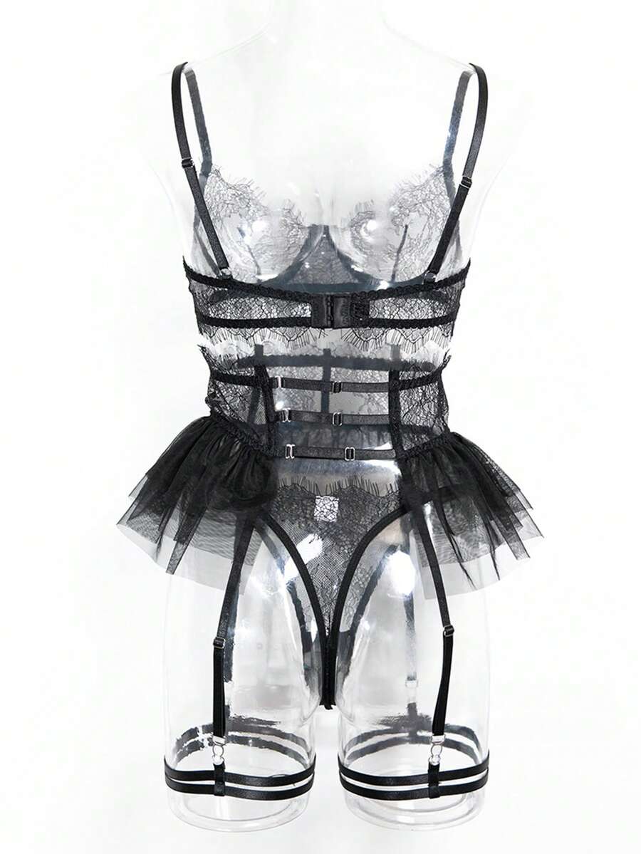 Front view of a 5-piece black lace lingerie set featuring an underwire bra with contrast mesh, matching garter belt, ruffle skirt, and high-rise thong.