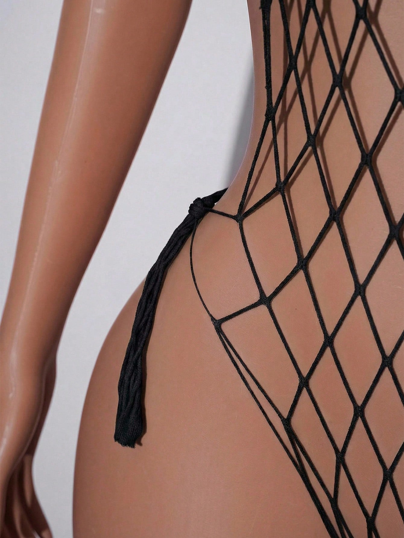 Women's burgundy sheer fishnet bodysuit with halter neckline, lace-up hollow out details, adjustable straps, and sleeveless Y2K styling.