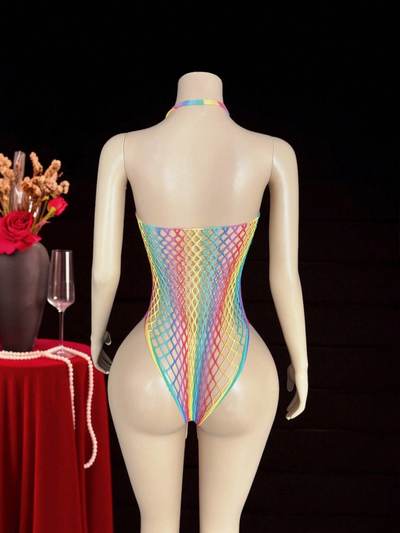 Women's sheer fishnet halter bodysuit with sleeveless design, backless tie-back detail, and high-stretch fabric in a wireless teddy style.