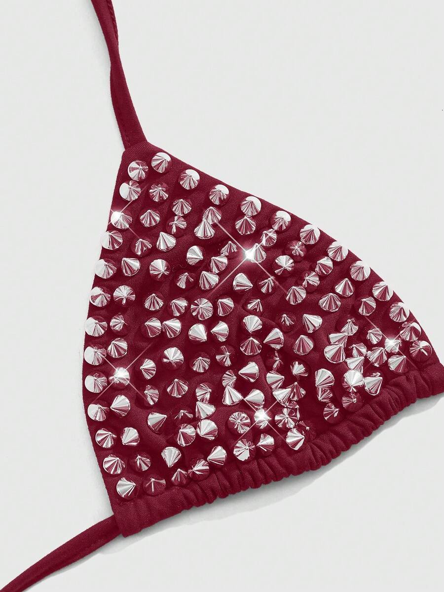 Women's black knitted halter micro crop top featuring studded details, high stretch fabric, and an asymmetrical hem.