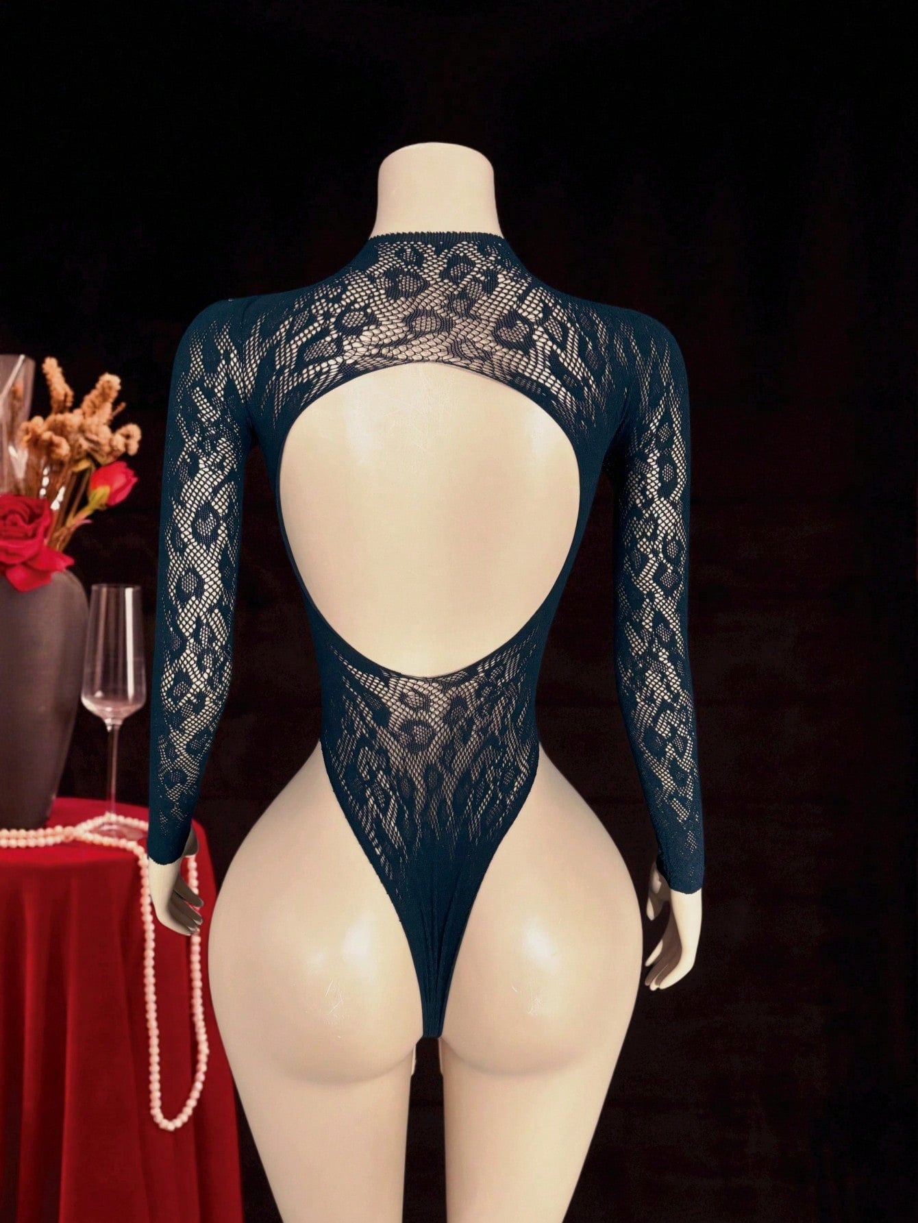 Women's black fishnet sheer bodysuit with adjustable straps, round neck, and high-stretch polyamide elastane fabric.