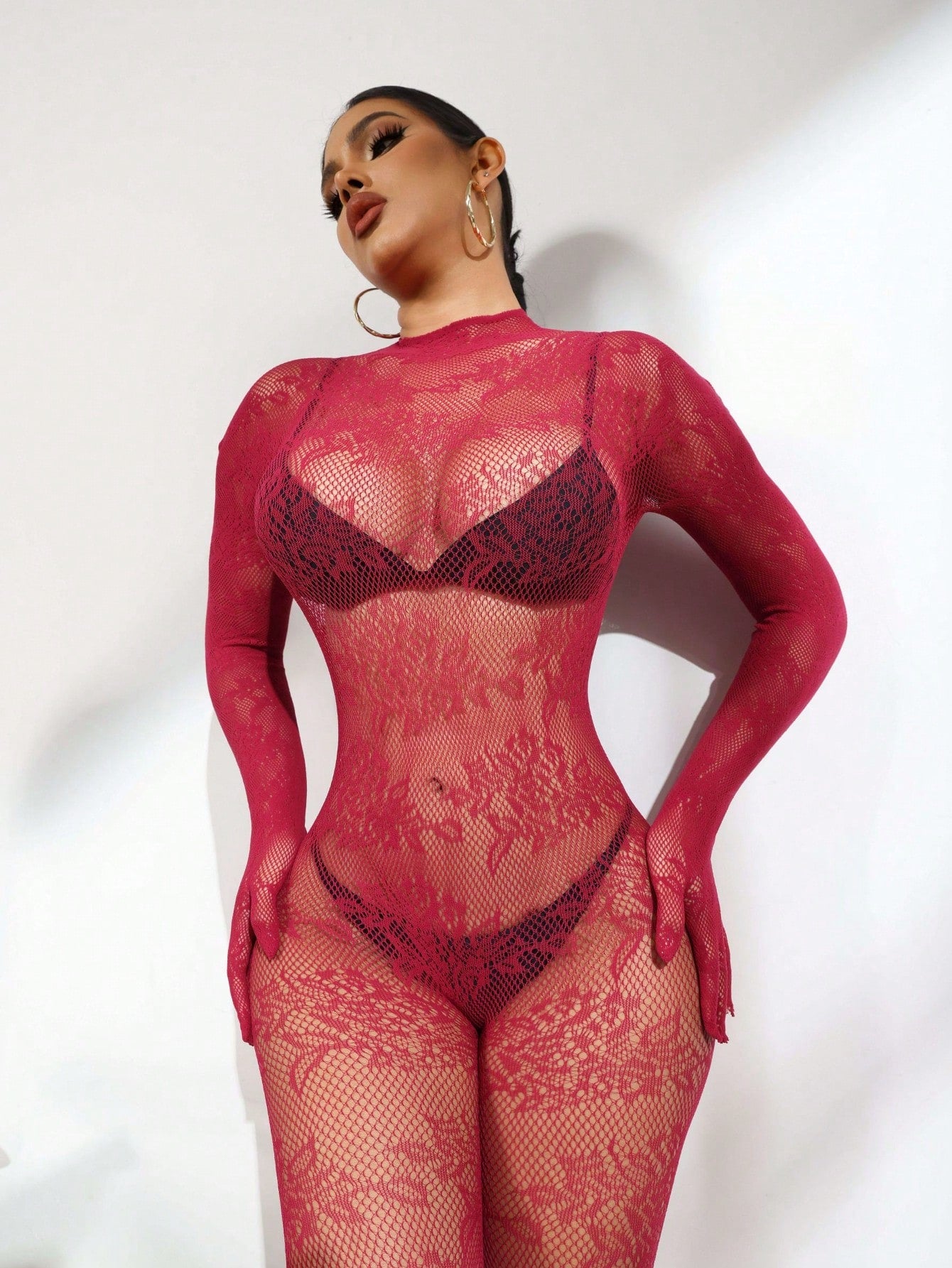 Women's sheer lingerie jumpsuit with contrast lace, cut-out details, long sleeves, stand collar, adjustable straps, and backless wireless design.