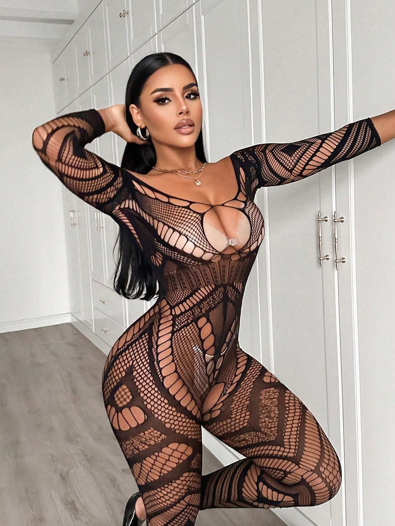 Women's black mesh bodysuit lingerie with hollow-out geometric design, plunge neckline, open back, adjustable straps, and three-quarter sleeves.