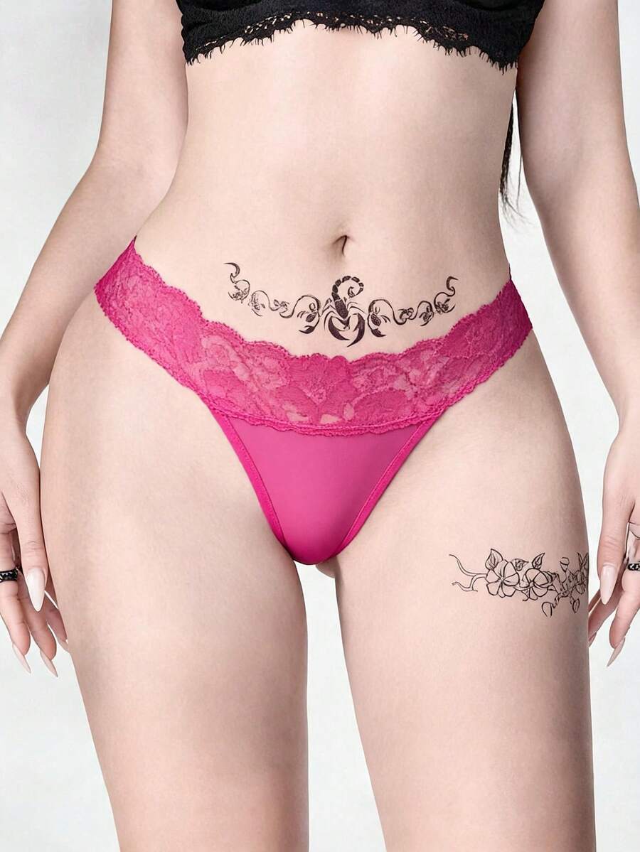 Gothic lace thong panties in black featuring low rise waistband with cross strap and bow detail