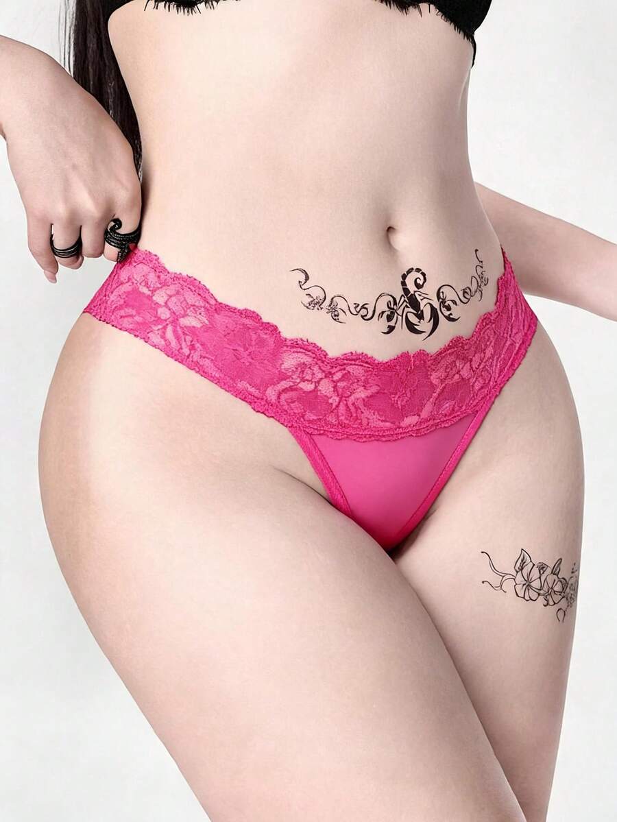 Gothic lace thong panties in black featuring low rise waistband with cross strap and bow detail