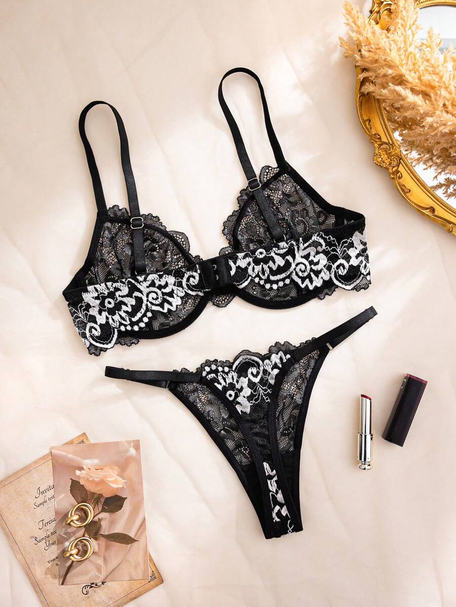 Women's black 2-piece lingerie set featuring a semi-sheer underwire bra with ring details and a matching low-rise thong.