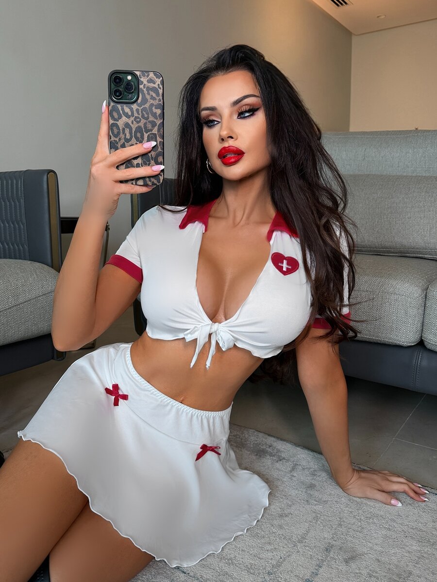 Red and white 3-piece women's lingerie costume set featuring a crossback top with bow detail, unlined short skirt, and matching bottom.