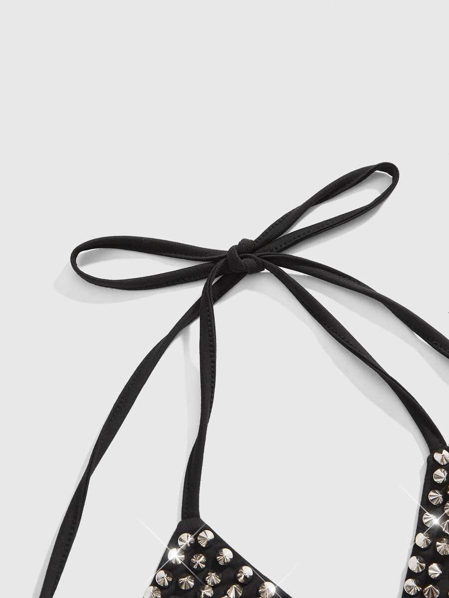 Women's black knitted halter micro crop top featuring studded details, high stretch fabric, and an asymmetrical hem.